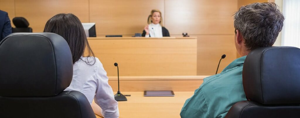 Lawyer and client listening to judge in the court room